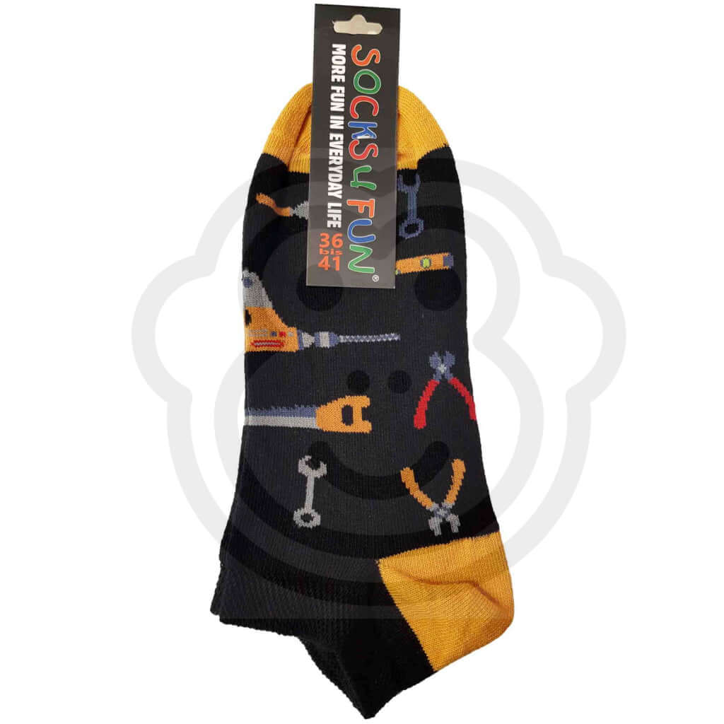 Mini socquettes outils bricolage avec motifs de scie, perceuse et pinces sur fond noir.