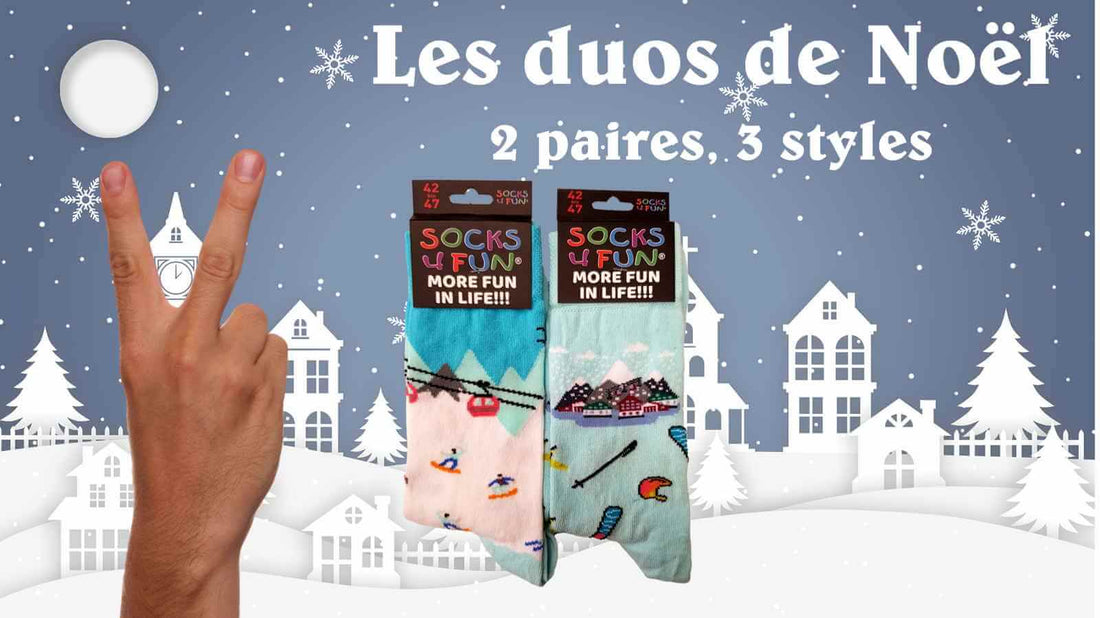 Deux doigts sur fond de village de montagne pour montrer que les chaussettes à offrir pour Noël sont en lots de 2 apires à dépareiller 